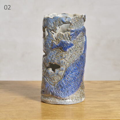 1: Grand corail blanc sur son socle en marbre. Mini éclat au socle. H. 22 cm L. 28 cm P. 24 cm 
2: Vase à la sirène, glaçure nuancée de bleu. H. 23 cm D. 11 cm 
3: Paire de bougeoirs en pierre, vers 1970. H. 32 cm L. 8 cm P. 8 cm 
4: Assiette à décor de personnage stylisé, vers 1990. H. 3 cm D. 26 cm 
5: Fossile pecten sud France H. 16 cm L. 23 cm P. 9 cm