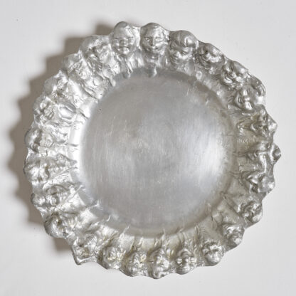 Grand plat en étain à décor de visages, Belgique début XXème.

Signé dans le décor E. Patris.

H. 4 cm D. 33 cm