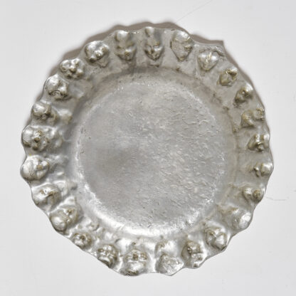 Grand plat en étain à décor de visages, Belgique début XXème.

Signé dans le décor E. Patris.

H. 4 cm D. 33 cm